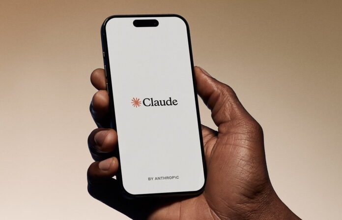 Hand holding a smartphone showing the Claude app by Anthropic