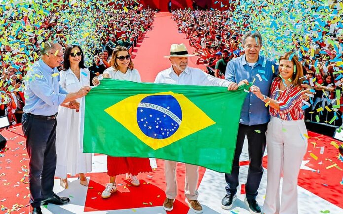 Lula and allies hold a Brazilian flag at the launch of his 2026 campaign in São Bernardo do Campo